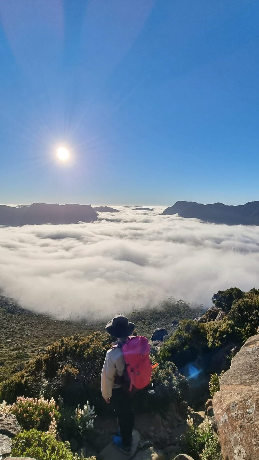 Autor contemplando un valle de nubes desde la cúspide de una montaña